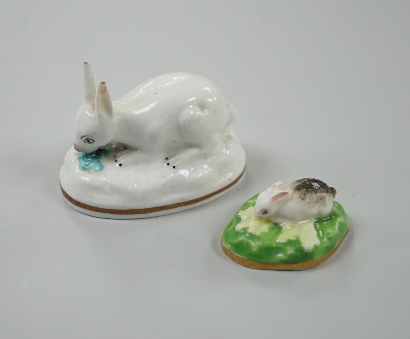 Two toy Staffordshire models of a recumbent rabbit and a bunny, both on oval bases, c.1830-50, (2). Tallest 4cm, Provenance Dennis G.Rice collection